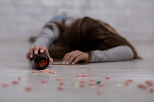 Tysiącletnia dama popełniająca samobójstwo przedawkowując antydepresanty, selektywna koncentracja na trzymaniu słoika z tabletkami — Zdjęcie stockowe