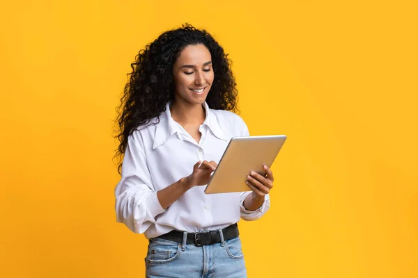 Dijital Tablet Kullanan Genç Kadın, Sarı Stüdyo Arkaplanı Üzerinde Sosyal Ağ Taraması — Stok fotoğraf