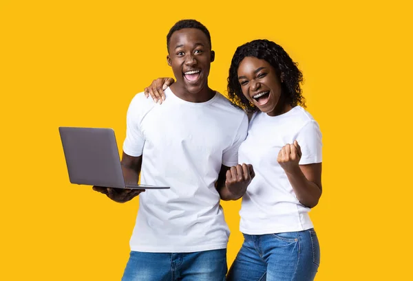 Excited black couple celebrating win with laptop — Stock Photo, Image