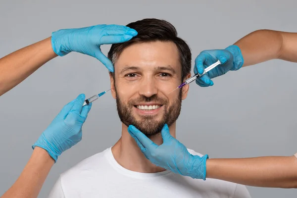 Feliz hombre de mediana edad recibiendo inyecciones de belleza en el salón — Foto de Stock