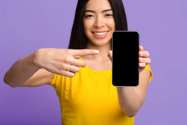 Positieve Aziatische dame wijzen op blanco zwarte smartphone scherm, Mockup Afbeelding — Stockfoto