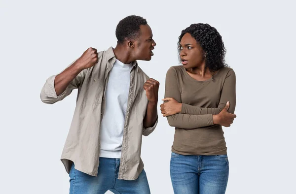 Angry black guy threatening his girlfriend with his fist — Stock Photo, Image