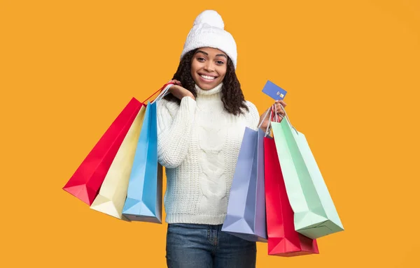 Sonriente mujer negra sosteniendo tarjetas de crédito y bolsas de compras — Foto de Stock
