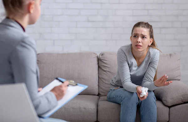 Servicio de ayuda psicológica. Paciente mujer deprimida que tiene sesión de psicoterapia con un consejero en el consultorio — Foto de Stock