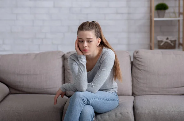 Concetto di salute mentale. Giovane donna che ha la depressione sul divano a casa — Foto Stock