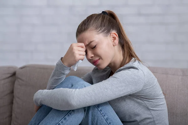 Lonely millennial woman feeling hopeless or desperate, crying on sofa at home — Stock Photo, Image