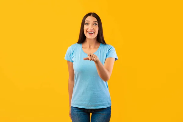 Mujer feliz señalando con el dedo a la cámara en el estudio — Foto de Stock