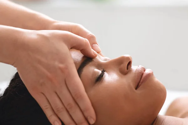 Massagista terapeuta esfregando afro-americano senhora testa — Fotografia de Stock