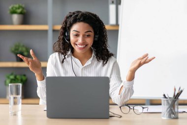 Üniversite hocası, koç webcam 'e bakın ve sınıfta konuşun. Bilgisayarda uzaktan kumandalı sanal öğretmenlik dersi verin. Afro-amerikalı mutlu bayan kara tahtada, işaret ediyor