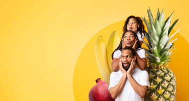 Canlı bir kolaj, renkli meyvelerin düzenlendiği bir ortamda aileyi şaşırtır. Arka plan sağlıklı gıdaların canlılığını, beslenmeyi ve canlılığı, kopyalama alanını vurguluyor.