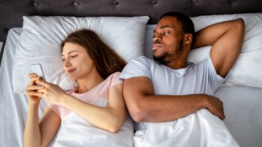 Sinirli siyahi adam kız arkadaşını kıskanıyor. Akıllı telefondan yatakta, üst manzarada. Milenyum adamı, alet bağımlısı karısı tarafından ihmal ediliyor ve görmezden geliniyor. Phubbing konsepti