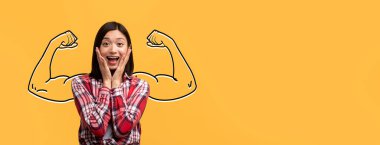 Neşeli Asyalı bir bayan, parlak sarı bir arka plana karşı gücünü ve coşkusunu sergiliyor, pazıların altını çiziyor ve ilham verici ve motive edici bir ortamda güçlü bir ruh sergiliyor..