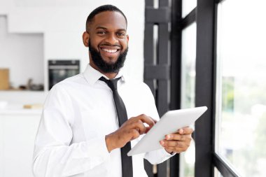 Gülümseyen Milenyum Afrikalı Amerikalı Erkek Girişimcinin Portresi Dijital Tablet Bilgisayar kullanarak İş Haberleri Okurken Çevrimiçi İçerideki İş Yeri Penceresinde Duruyor, Kameraya Bakıyor