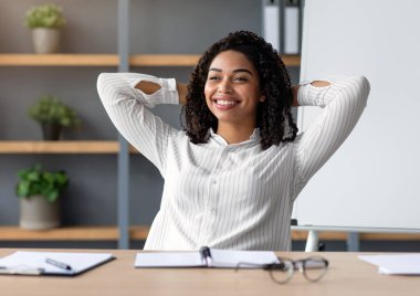 Sanal toplantı koronavirüs önleme, yeni normal, uzak çalışma. Uzak bir sınıf, rahatla ve ara ver. Gülen milenyum güzeli siyah kadın karatahta arka planda iş yerinde dinleniyor.