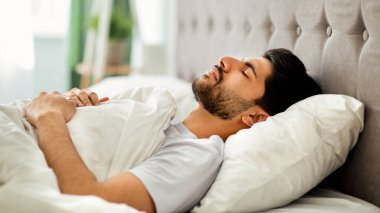 Derin erkek uykusu. Genç Arap adam evdeki rahat yatağında huzur içinde uyuyor, gözleri kapalı yatıyor. Dinlenme, dinlenme ve şekerleme zamanı.