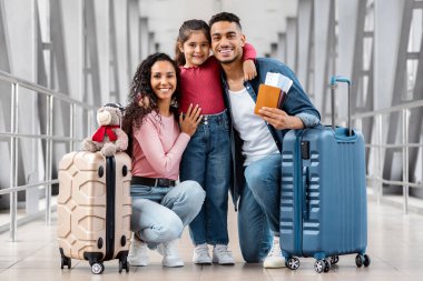 Havalimanı Terminalinde Mutlu Orta Doğulu Aile Pozisyonu Gülümseyen Arap Ebeveynler ve Kızları Çantaları, Pasaportları ve Biletleri Taşırken, Birlikte Seyahatin keyfini Çıkarırken