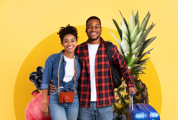 İki genç yetişkin taze meyvelerle dolu canlı bir arka plana gülümsüyor. Neşe saçıyorlar, sağlıklı yaşam tarzlarını ve besleyici yiyeceklere olan sevgilerini sergiliyorlar..