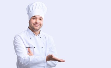 Restoran Şefi, Beyaz Stüdyo Arkaplanında Boş Alan Pozisyonunu Göstererek El Hareketi Yapıyor.