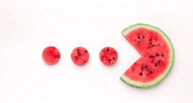 Meyve oyunu. Karpuz Pacman küçük kırmızı yuvarlak parçalar yiyor, beyaz arka planda izole edilmiş, üst manzara