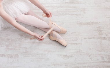 Güzel bacaklar beyaz ahşap zemin arka plan, kopya alanı ile yukarıdan üstten görünüm pointe ayakkabılara koyar genç balerin. Bale pratik. Balet ince zarif metrelik güzel.