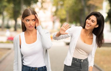 Utangaç kız, dışarıda parkta yürürken iletişim problemleri yaşayan bayan arkadaşla buluşmaktan kaçınıyor. Seçici Odaklanma