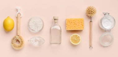 Çevre dostu doğal temizleyicilerle düz kompozisyon. Kabartma tozu, tuz, limon, pembe arka planda bambu fırçaları, panorama