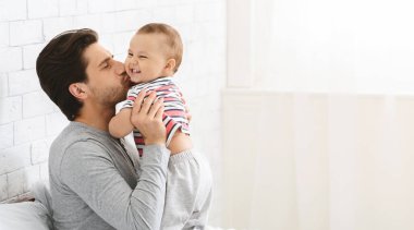 Mutlu babalık izni. Genç adam onun sevimli bebek oğlu öpüşme, bebek bakıcılığı zevk, boş alan ile panorama