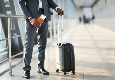 Tanımlanamayan girişimci pasaport ve uçuş biletleri kapalı havalimanında bagajla bekliyor. Kırpılmış, Seçici Odaklanma