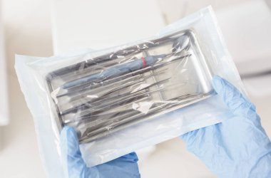 Steril, farklı diş aletleri ve doktor ellerindeki aletleri kapatın