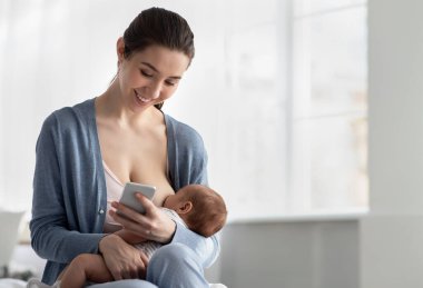 Mutlu Genç Anne, yeni doğmuş bebeğini emzirirken akıllı telefon kullanıyor, cep telefonuyla mesajlaşıyor, yeni uygulamalara bakıyor ya da evde emzirirken internetten alışveriş yapıyor.