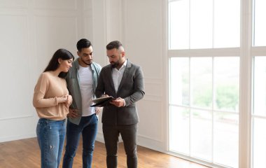 Genç evli Orta Doğulu çift emlakçı ya da komisyoncuyla anlaşma yapıyor. Profesyonel mali danışman ya da satıcı toplantıda milenyum müşterileriyle sözleşme detaylarını açıklıyor