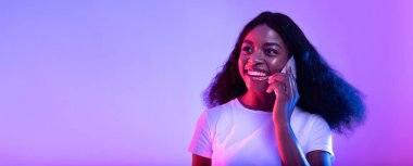 Neon ışıkta akıllı telefondan konuşan mutlu, genç siyahi kadın, boş alanlı pankart tasarımı. Neşeli Afrikalı Amerikalı kadın telefonla konuşuyor, sohbet ediyor, iletişimin tadını çıkarıyor.