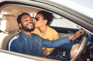 Yeni araba sahipleri. Siyah Eş Mutlu Kocanı Öpüyor Yeni Lüks Araba 'da Oturuyor. Seçici Odaklanma