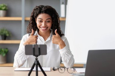 Eğlenerek öğren. İnternet 'te mutlu Afro-Amerikan bayan öğretmenler webcam, e-öğrenme, uzaktan eğitim sayfalarına bakın. Gösteride özel ders, oturma odasının içindeki akıllı telefon webcam 'ine bak.