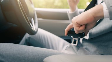 Erkek eli arabada emniyet kemerini bağlar. Araba sürmeden önce emniyet kemerini takın. Şoför emniyet kemerini takıyor. Sürücü koltuğunda oturan Avrupalı genç adam, yakın çekim