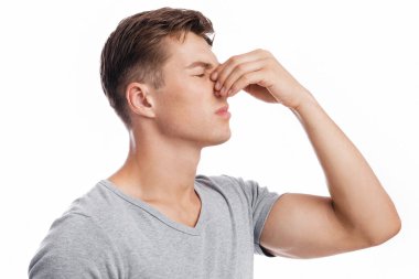 Bin yıllık üzgün, beyaz, çekici bir adam göğüs göğüse savaşıyor, yaralanma üstüne acı çekiyor, kanama ve baş ağrısı var, beyaz arka planda izole edilmiş, profilde. Burun akışı, travma ve sağlık sorunları