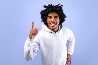 Havalı siyahi genç yaratıcı fikirlere sahip, yukarı bakan, AHA anını mavi stüdyo arka planında yaşayan. Çılgın Afro-Amerikalı genç adam, Eureka yapıyor, heyecanlanıyor.