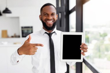 Mock Up Template. Portrait Of Happy Smiling Black Business Man Showing Tablet With Blank Black Screen, Standing By Window At Home Or Coworking Office, Free Copy Space. People, Technology, Work Concept