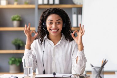 Sanal ders sınıfının, covid-19 'un sosyal mesafenin ve evde modern eğitimin mükemmel bir sonucu. Okula dönelim. Kulaklık takan mutlu siyahi bayan, el işaretini göster, webcam 'e bak.