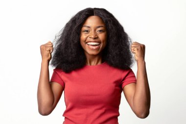 Büyük Galibiyet. Coşkulu Siyah Kadın 'ın Portresi Heyecanla Yumruk Kalkması, Mutlu Afrikalı Amerikalı Kadın Başarılı Oluşun Kutlanması, Zafere Duygusal Tepkiler, Beyaz Arkaplanda Poz Verme