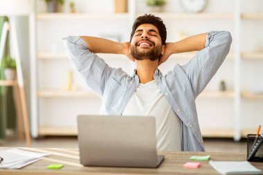 İşe ara verelim. Rahat Arap adam işten sonra dizüstü bilgisayarla dinleniyor. Mutlu adam el ele tutuşuyor, gözleri kapalı, evde çalışıyor.