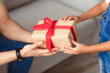 Bu hediye senin için. Yakından bakınca, kucağında küçük bir kızın hediye paketini tutarken ve verirken, babasına sürpriz yaparken, babasıyla doğum gününde veya doğum gününde, evde kutlama yapan bir adam.
