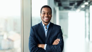 Başarılı bir siyahi iş adamı modern ofiste kameraya gülümsüyor. İş Başarı, Kariyer, Liderlik ve Girişimcilik Konsepti. Seçici Odaklanma