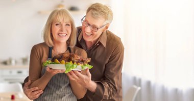 Şükran Günü ya da Noel hindisi pişiren Kafkasyalı yaşlı çift mutfaktaki aile kutlaması için geleneksel yemek hazırlıyor. Kutlama etkinliği konsepti