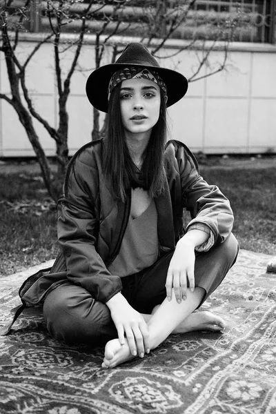 黑白照片时尚的年轻女子戴着时髦的帽子和摆在户外 — 图库照片