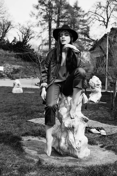 スタイリッシュな若い女性おしゃれな帽子をかぶっていると屋外でポーズの黒と白の写真 — ストック写真