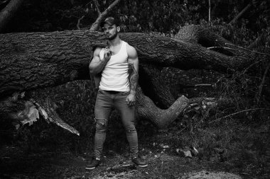 Yakışıklı genç adamın denim ceket poz açık havada tutarak siyah ve beyaz fotoğraf