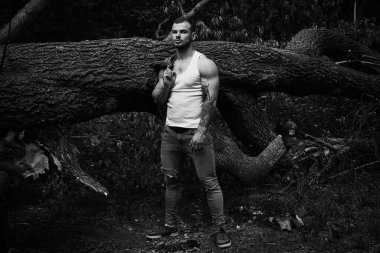 Yakışıklı genç adamın denim ceket poz açık havada tutarak siyah ve beyaz fotoğraf