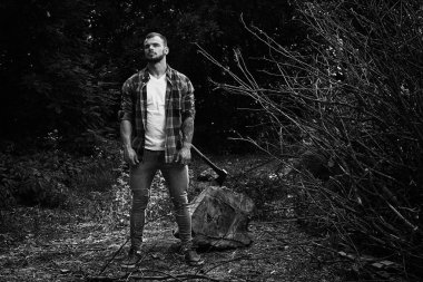 Siyah ve beyaz fotoğraf balta açık havada poz ile yakışıklı genç adamın