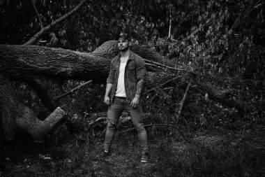 Siyah ve beyaz fotoğraf yakışıklı genç erkek adam açık havada yaz ormanda poz